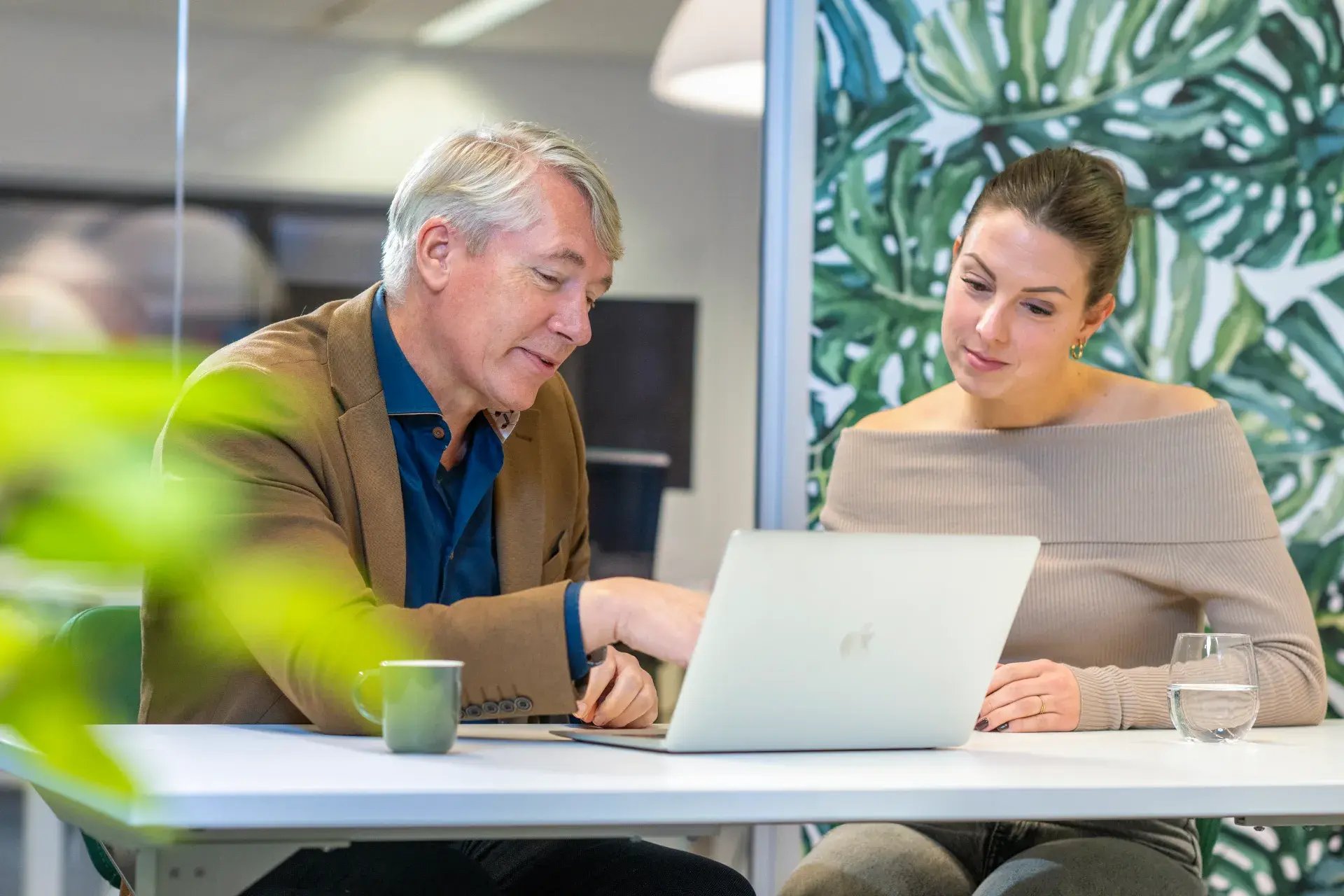 Klaas laat aan zijn collega Fenna van Bright Digital iets op de laptop zien over HubSpot