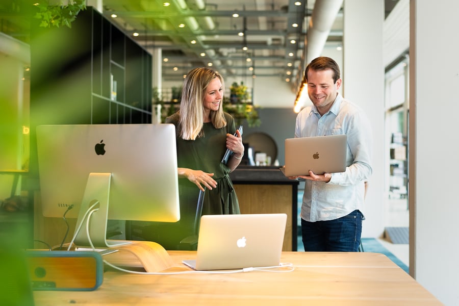 collega's Daan en Roos die in het kantoor van Bright Digital staan en een vraag over HubSpot aan elkaar vragen